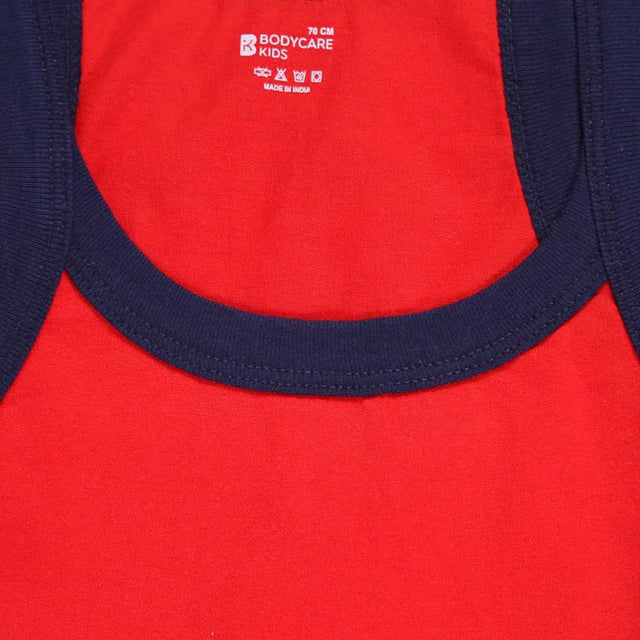 Close-up of red kids cotton innerwear vest with navy blue neckline trim