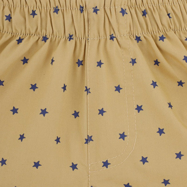 Close-up of kids' yellow innerwear with blue star pattern and elastic waistband