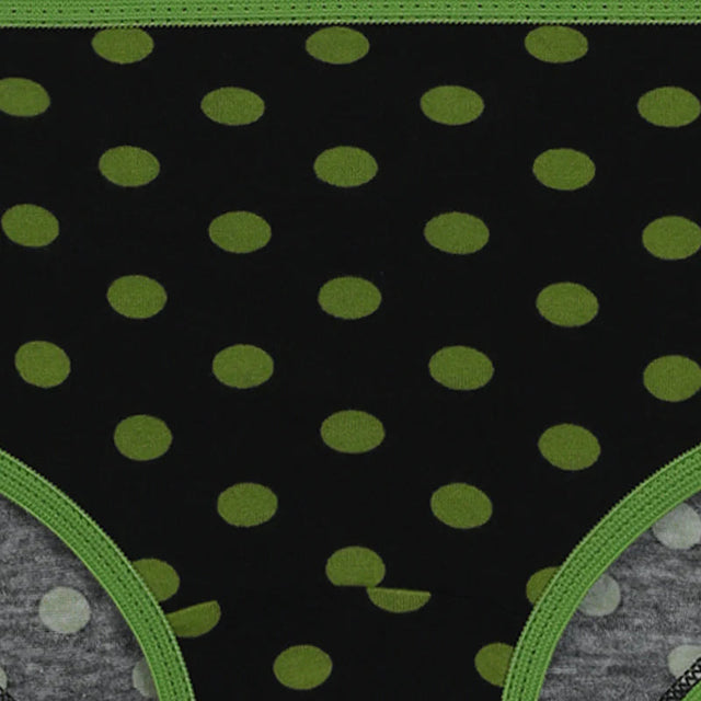 Black kids underwear with green polka dots and green trim, close-up view