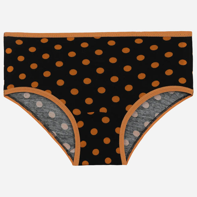 Black kids underwear with orange polka dots and orange trim, laid flat on white background