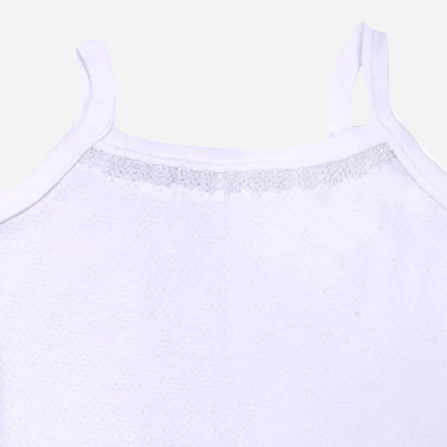 Close-up of white kids camisole with lace detail and thin shoulder straps on plain background