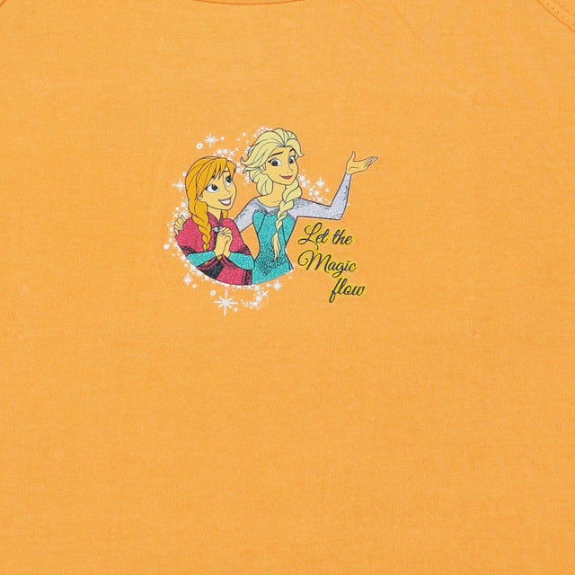 Orange kids innerwear top with graphic of two animated girls and 'Let the Magic flow' text