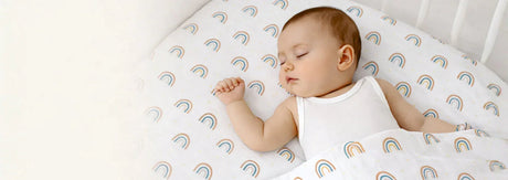 Sleeping baby wearing soft sleeveless innerwear on Bodycare Unisex Cot Sheet for comfortable night sleep