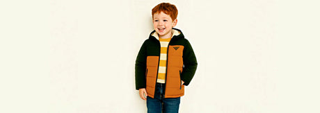 Young boy wearing a padded winter jacket and sweatshirt for cold weather protection