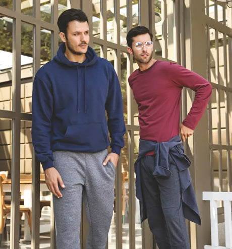 Two men wearing casual winter apparel with sweatshirts and joggers standing outdoors