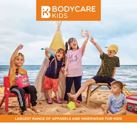 Kids wearing colorful summer t-shirts and innerwear playing on the beach in front of a tent.