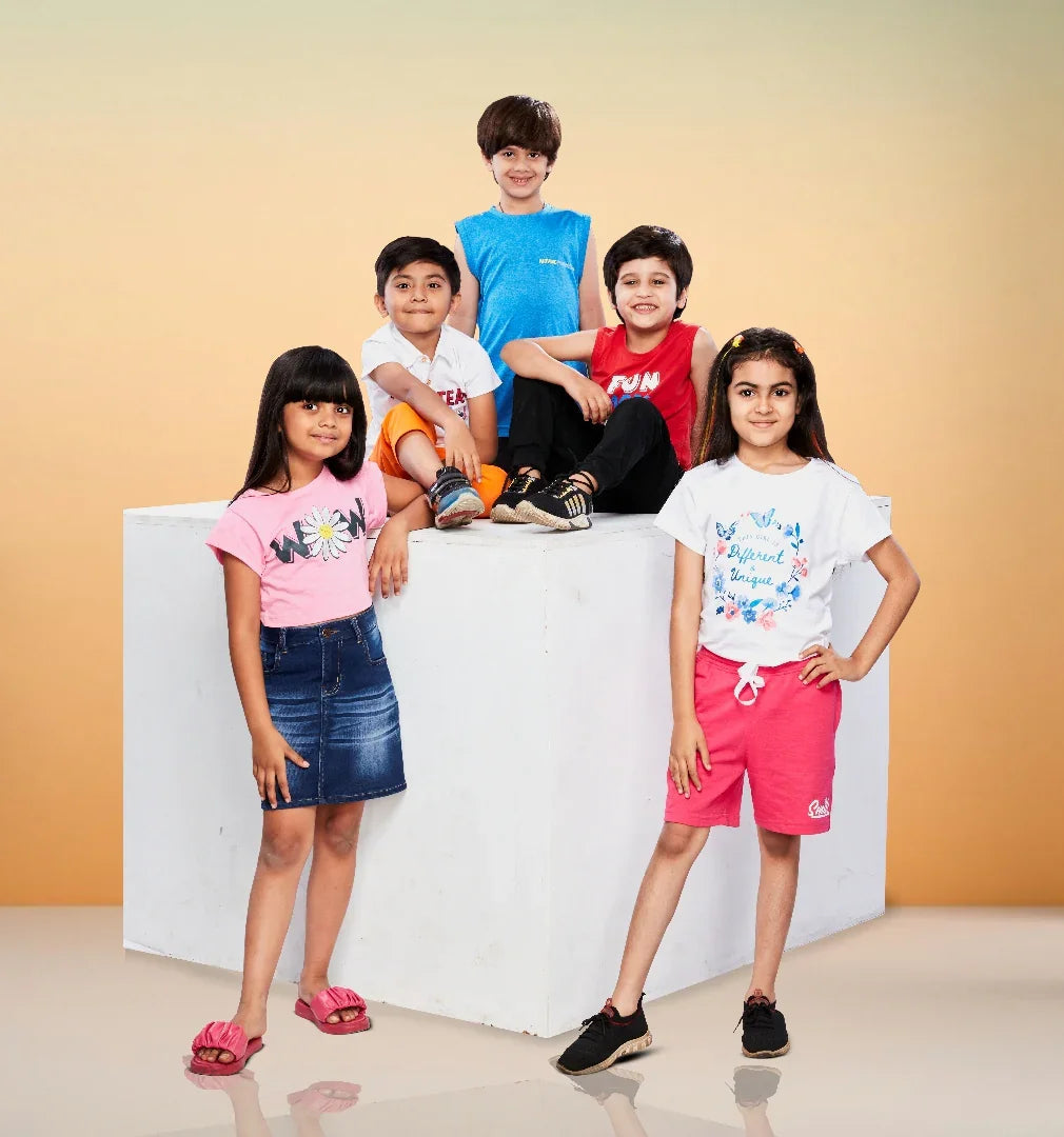 Group of kids in colorful summer apparel posing cheerfully against a soft orange background