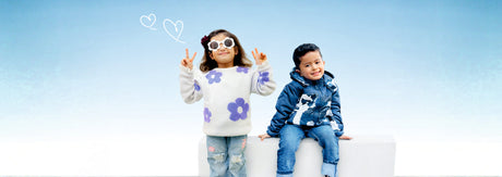 Two kids wearing winter jackets and sweatshirts, sitting outdoors in warm and stylish winter clothing