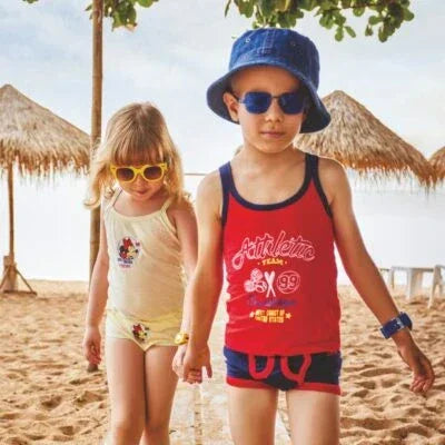 Kids wearing comfortable innerwear and sunglasses walking on a sandy beach