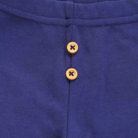 Close-up of navy blue kids innerwear fabric with two brown buttons and visible stitching