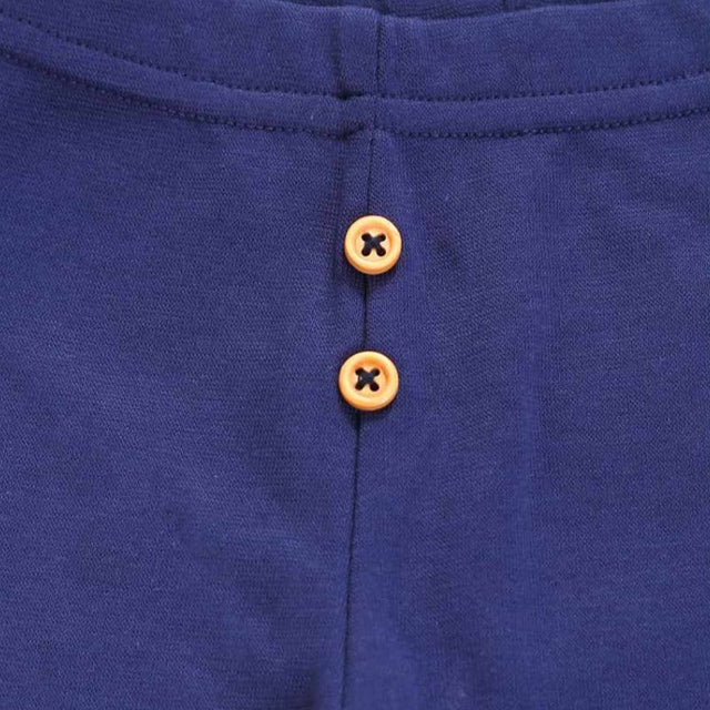 Close-up of navy blue kids innerwear fabric with two brown buttons and visible stitching