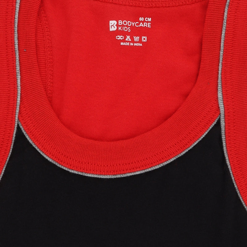 Close-up of kids innerwear tank tops in red and black with contrast trim and care label