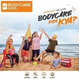 Happy kids in comfortable summer apparel playing on the beach with sea and tent backdrop