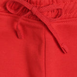 Close-up of red kids pants with elastic waistband and drawstring tie, soft fabric