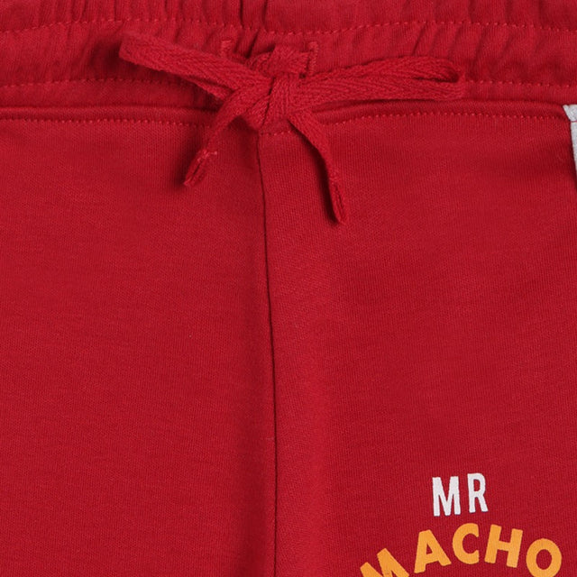 Close-up of red kids shorts with drawstring waist and 'MR MACHO' text print