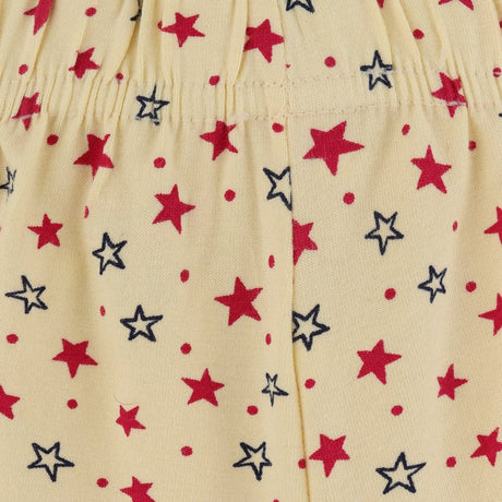 Yellow kids innerwear fabric with red and navy stars and dots pattern, close-up view