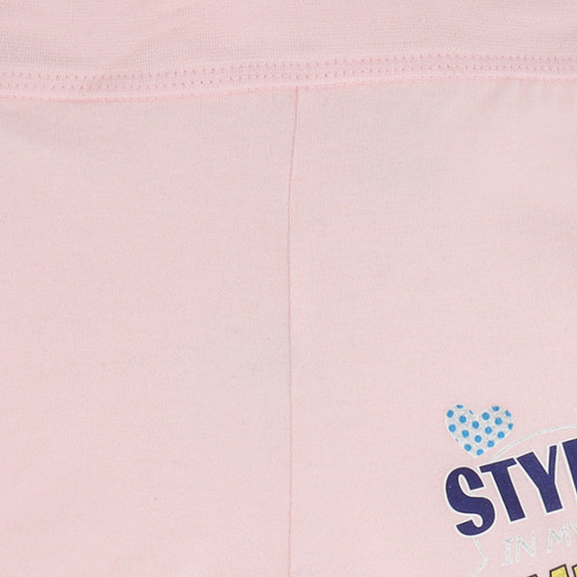 Close-up of light pink kids innerwear with blue polka dot heart and printed text detail