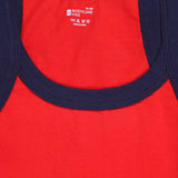 Close-up of red kids cotton innerwear vest with navy blue neckline trim