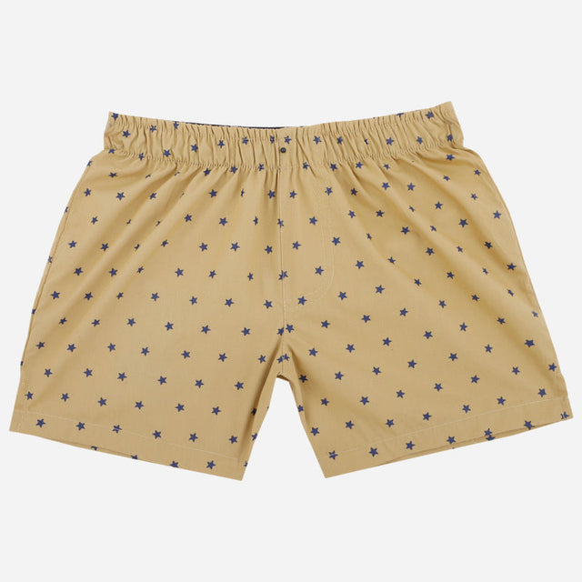 Beige kids boxers with navy blue star print and elastic waistband, laid flat on white background.