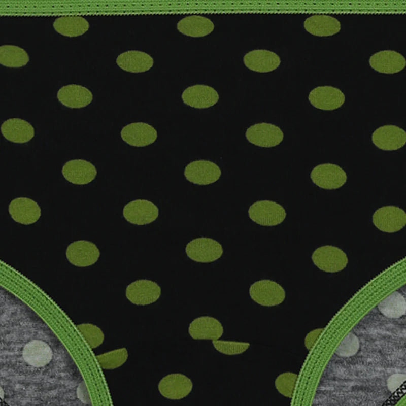 Black kids underwear with green polka dots and green trim, close-up view