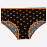 Black kids underwear with orange polka dots and orange trim, laid flat on white background