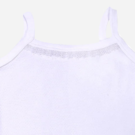 Close-up of white kids camisole with lace detail and thin shoulder straps on plain background
