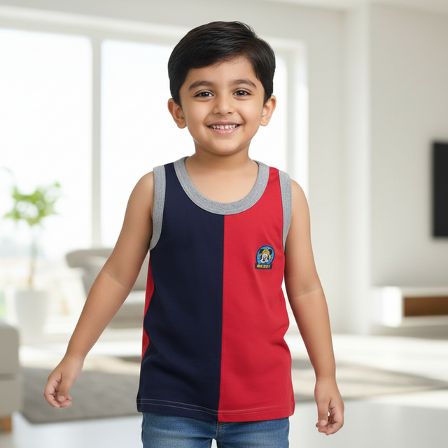 Smiling boy wearing sleeveless red and navy kids innerwear vest with grey trim indoors