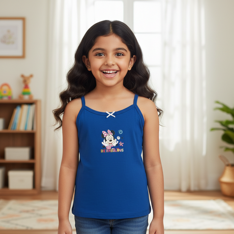 Smiling girl in blue camisole with cartoon print, kids innerwear, bright indoor setting