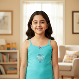 Smiling girl wearing turquoise kids camisole with 'Magic Fashion Look' print in a cozy living room